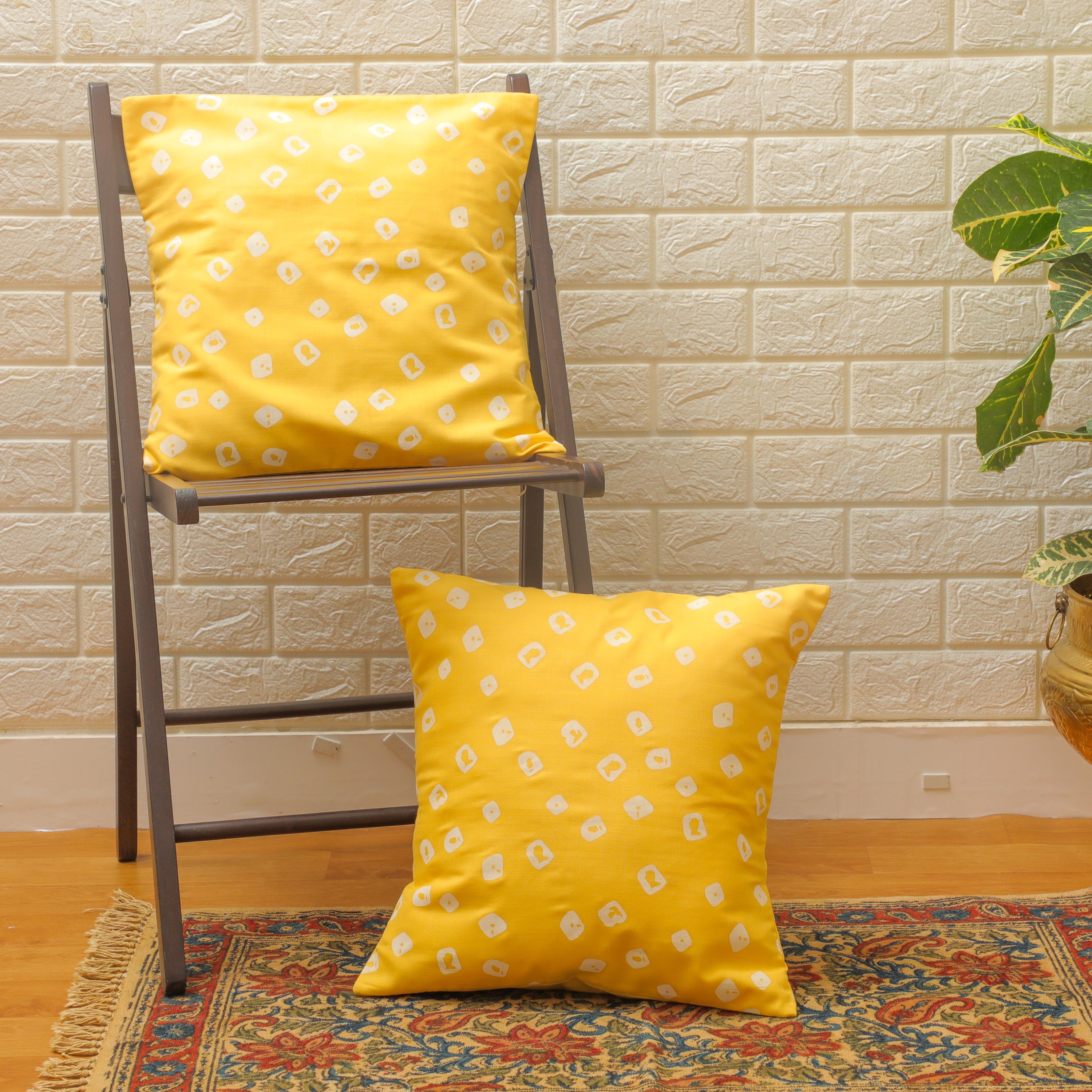 Bandhini cotton printed cushion with white print on a yellow background.