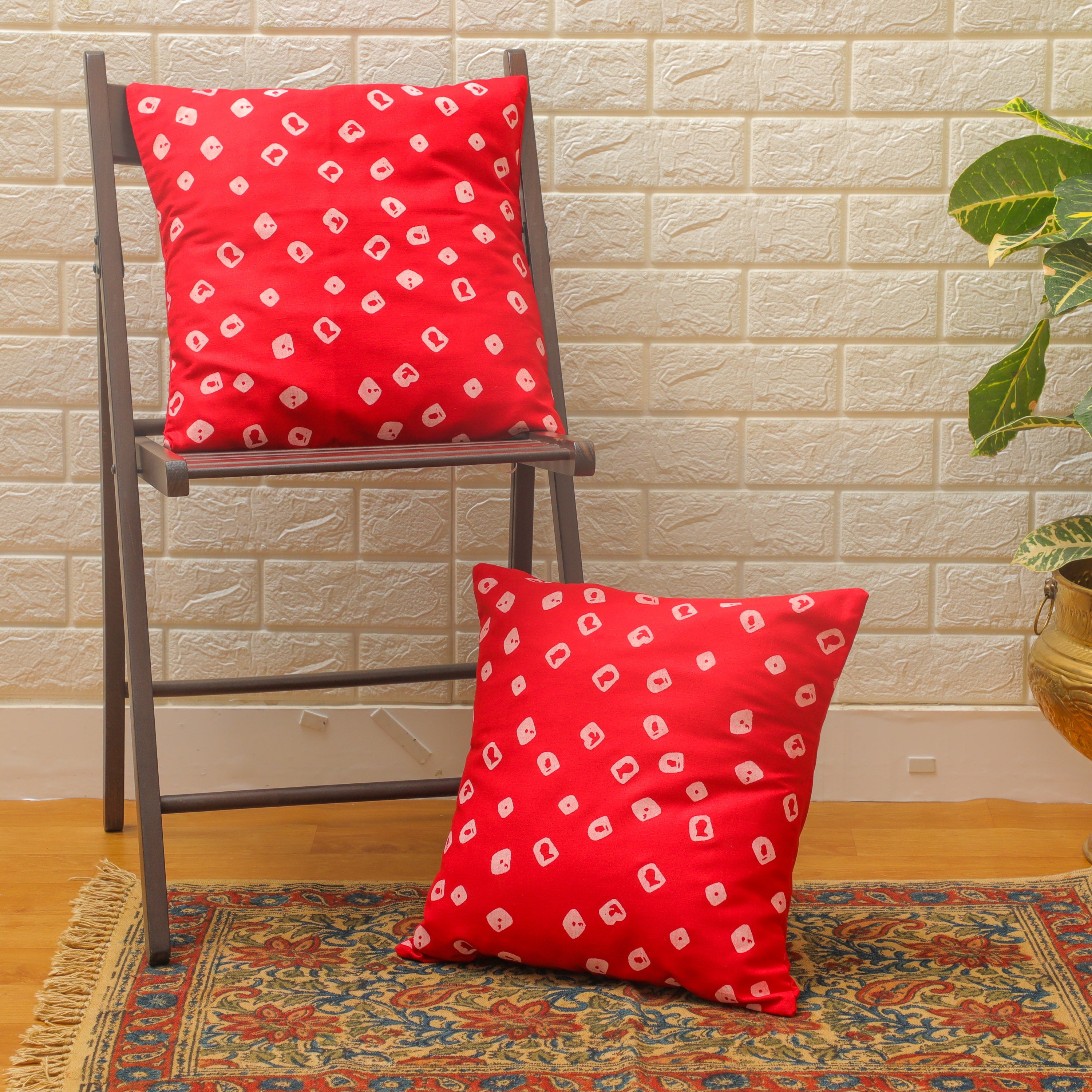Made from soft cotton, this red cushion adds a pop of color and texture to any space.