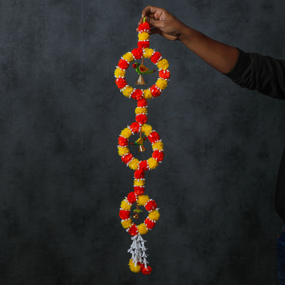 This garland is crafted from artificial flowers and designed with a colorful parrot pattern with hanging bells.