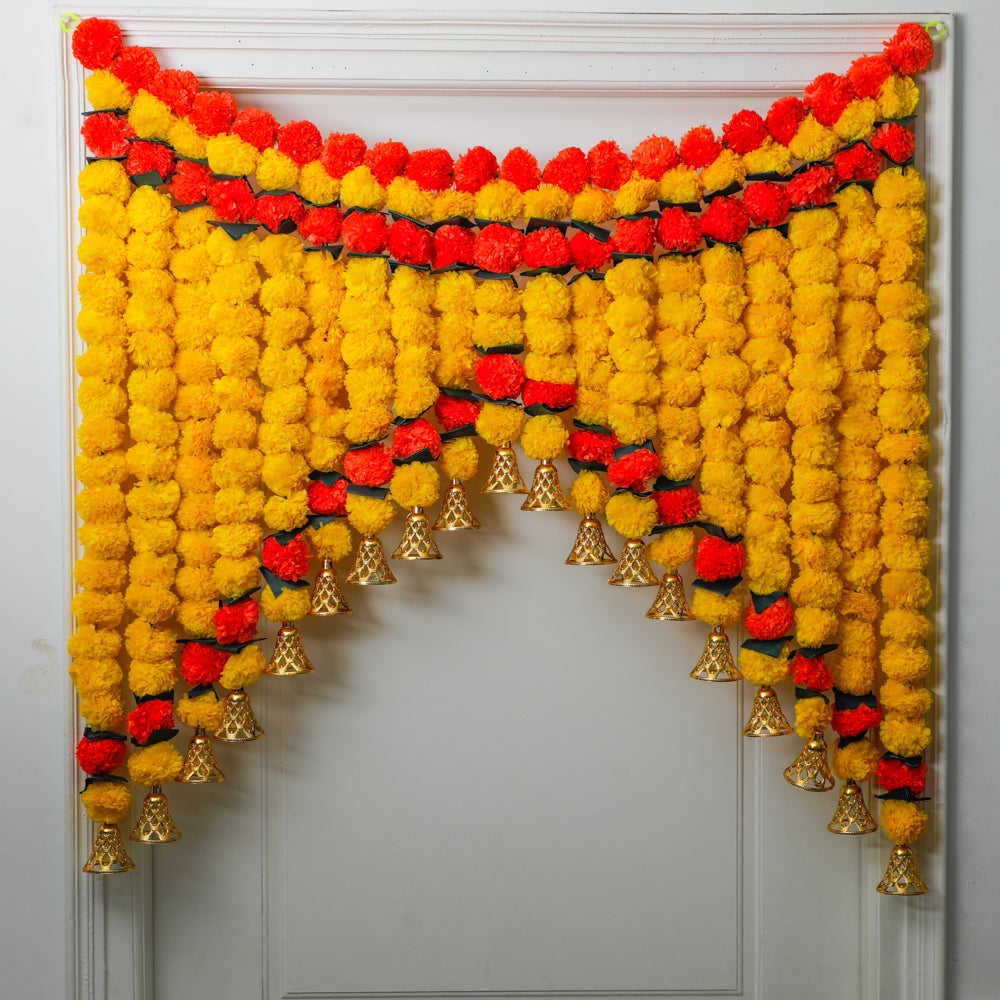Our Toran door-hanging, adorned with artificial marigold flowers and golden-coated hanging bells, is the perfect choice. 