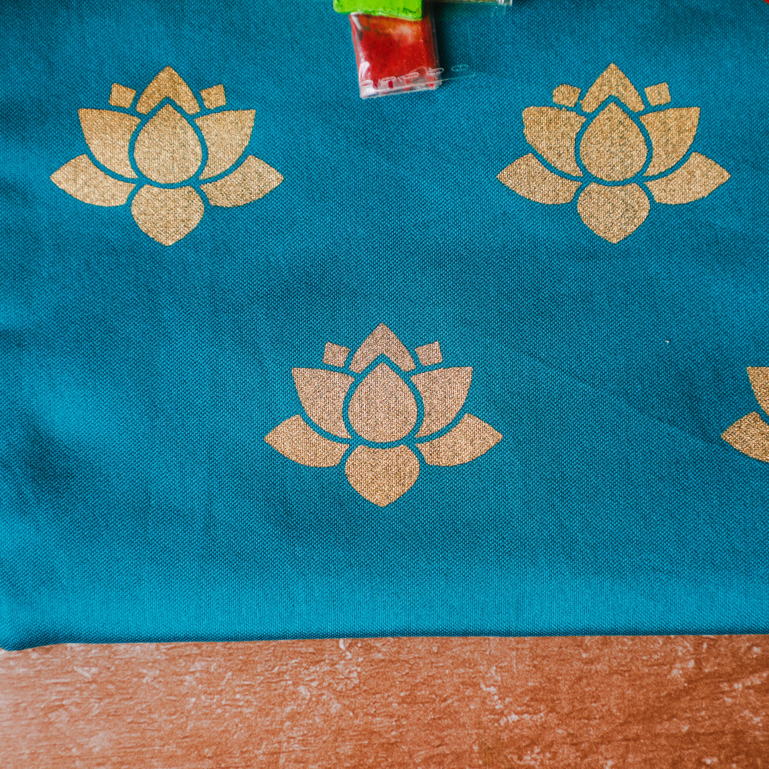 printed golden lotus design on blue pouch