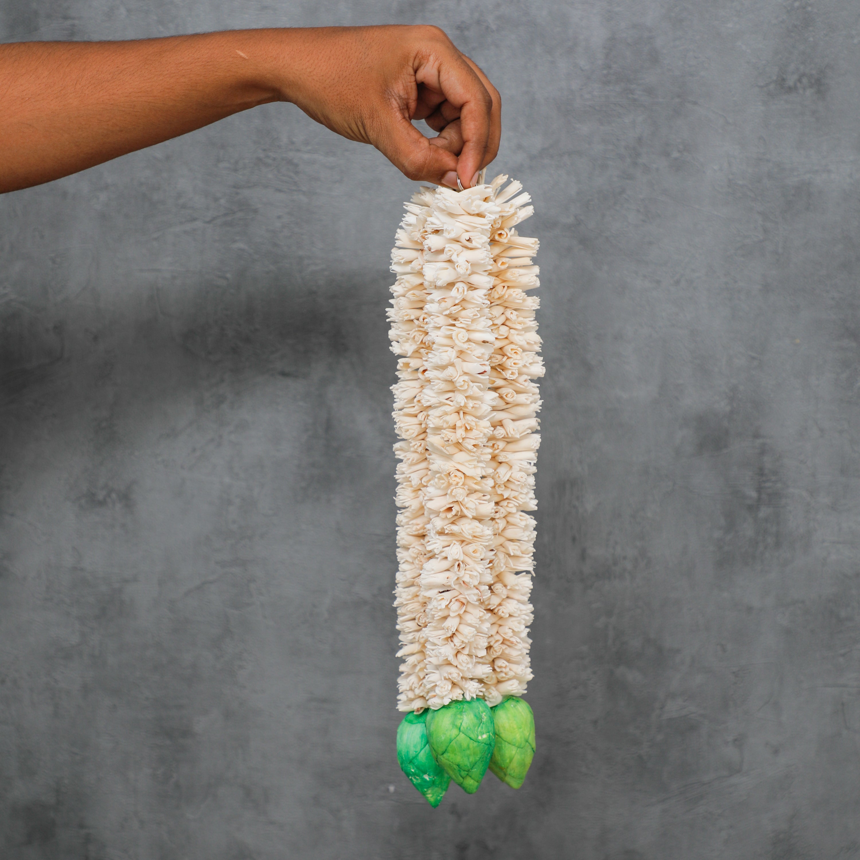 charming hanging decoration featuring green lotus flowers made from shola wood. Such a piece can be used to adorn walls, windows, or any other suitable spot 