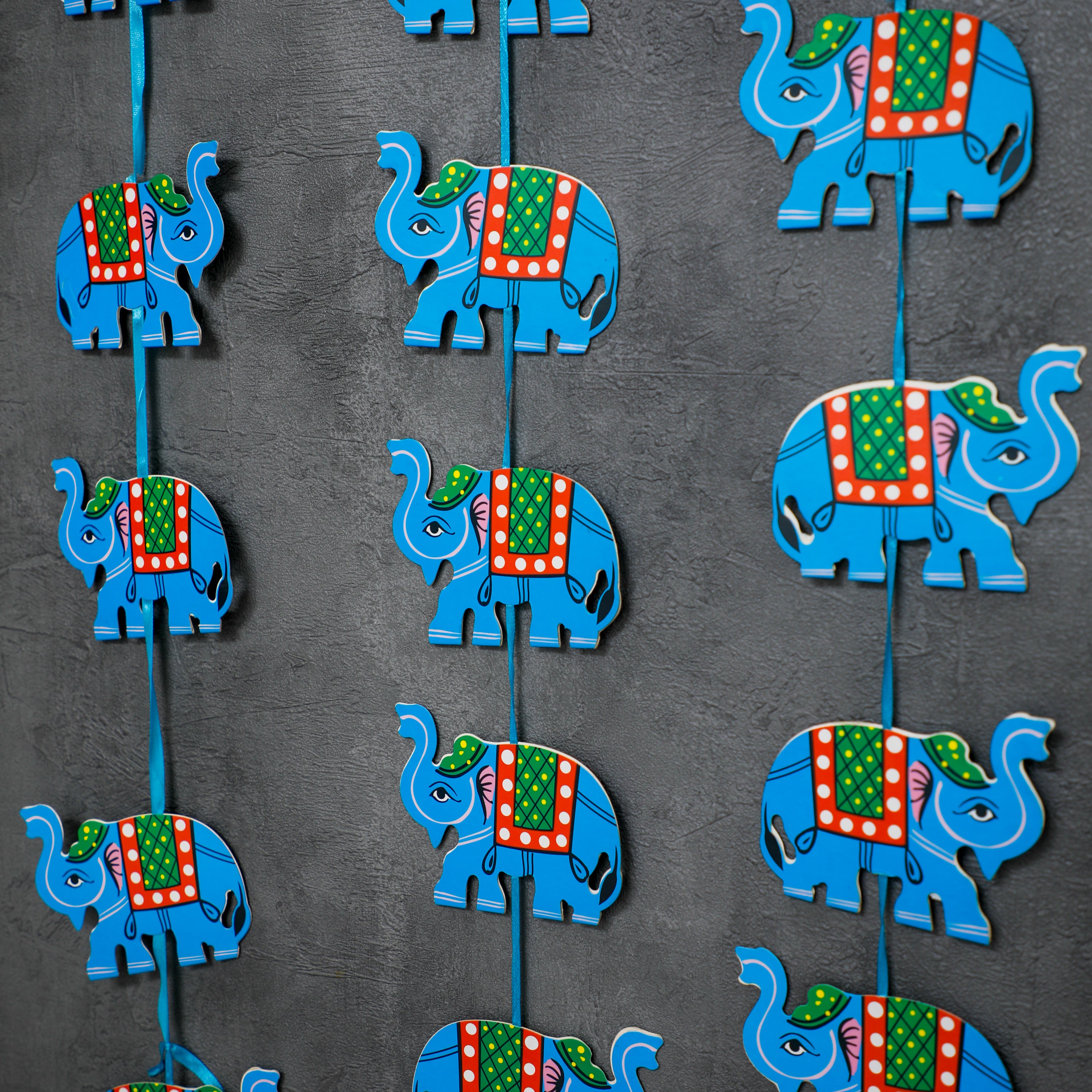 The elephants are then evenly spaced along the string, creating a visually appealing and cohesive garland.