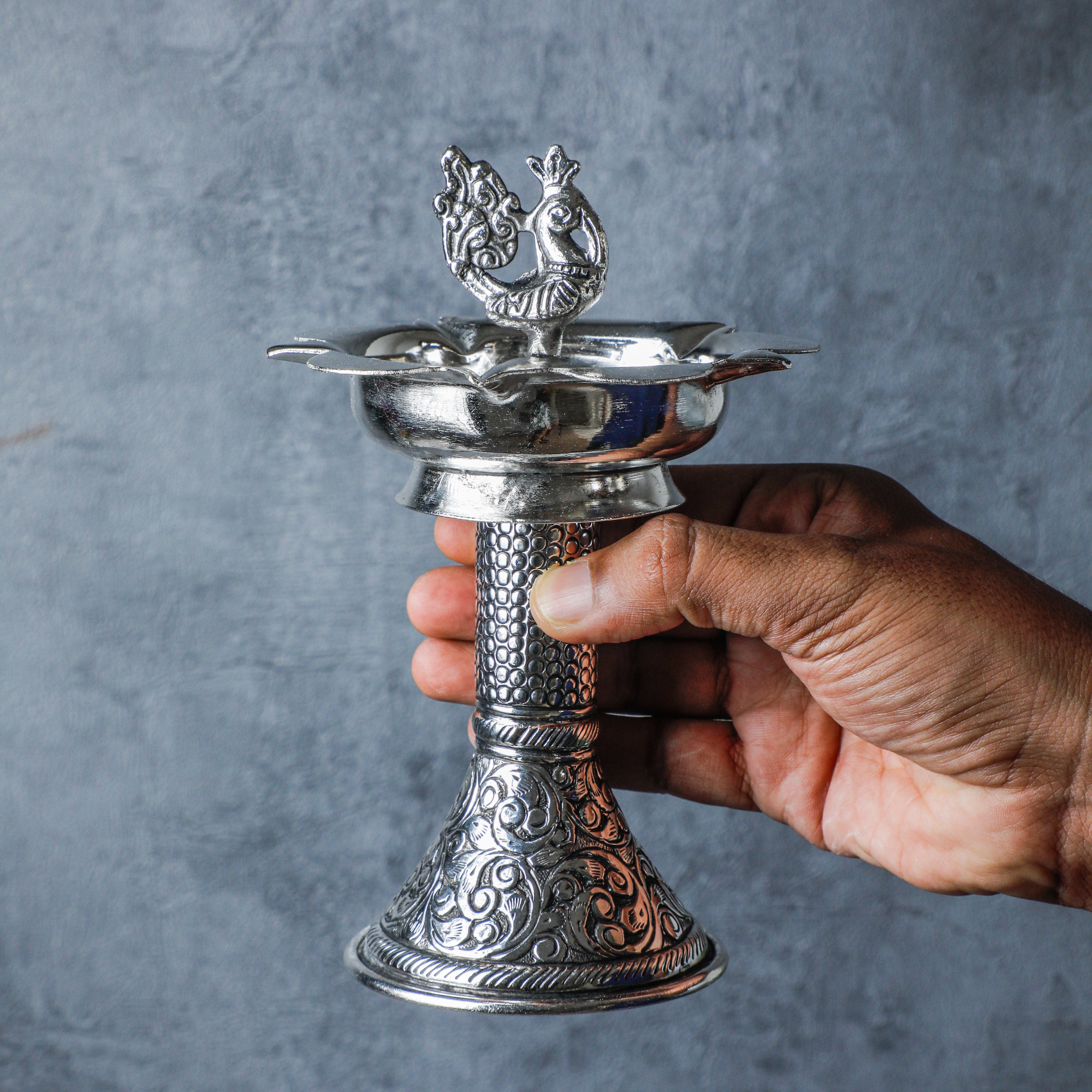 Designed to captivate hearts, this diya symbolizes grace and beauty with its intricate detailing and shimmering silver plating.