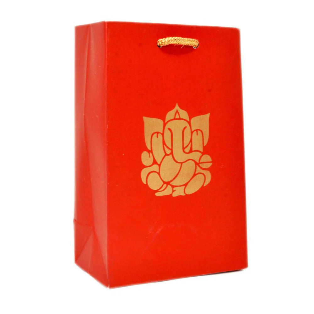 A red paper gift bag with a gold foil Ganesha graphic on the front and a gold hanging loop at the top, shown against a plain white background.