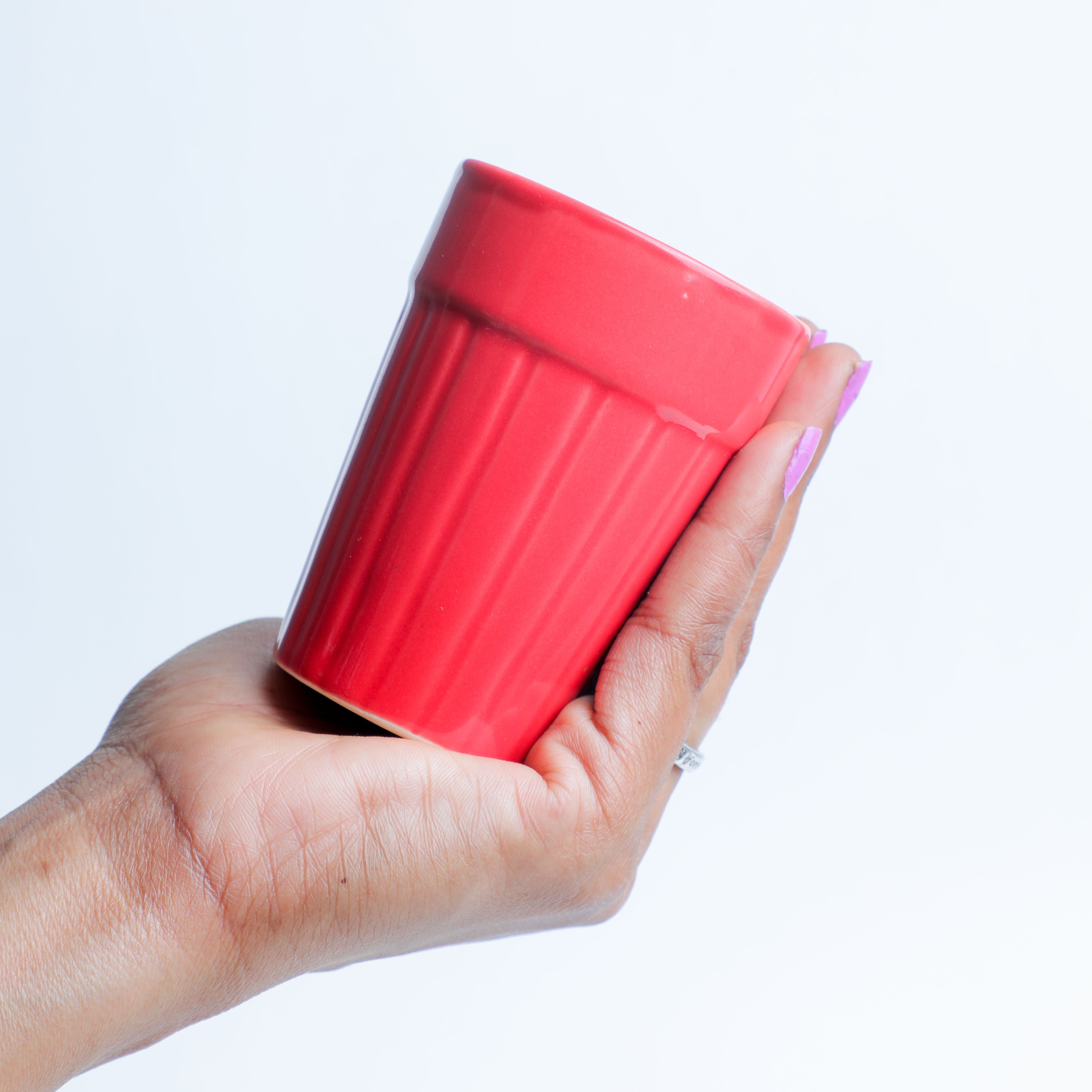 Holding the red color ceramic tea glass