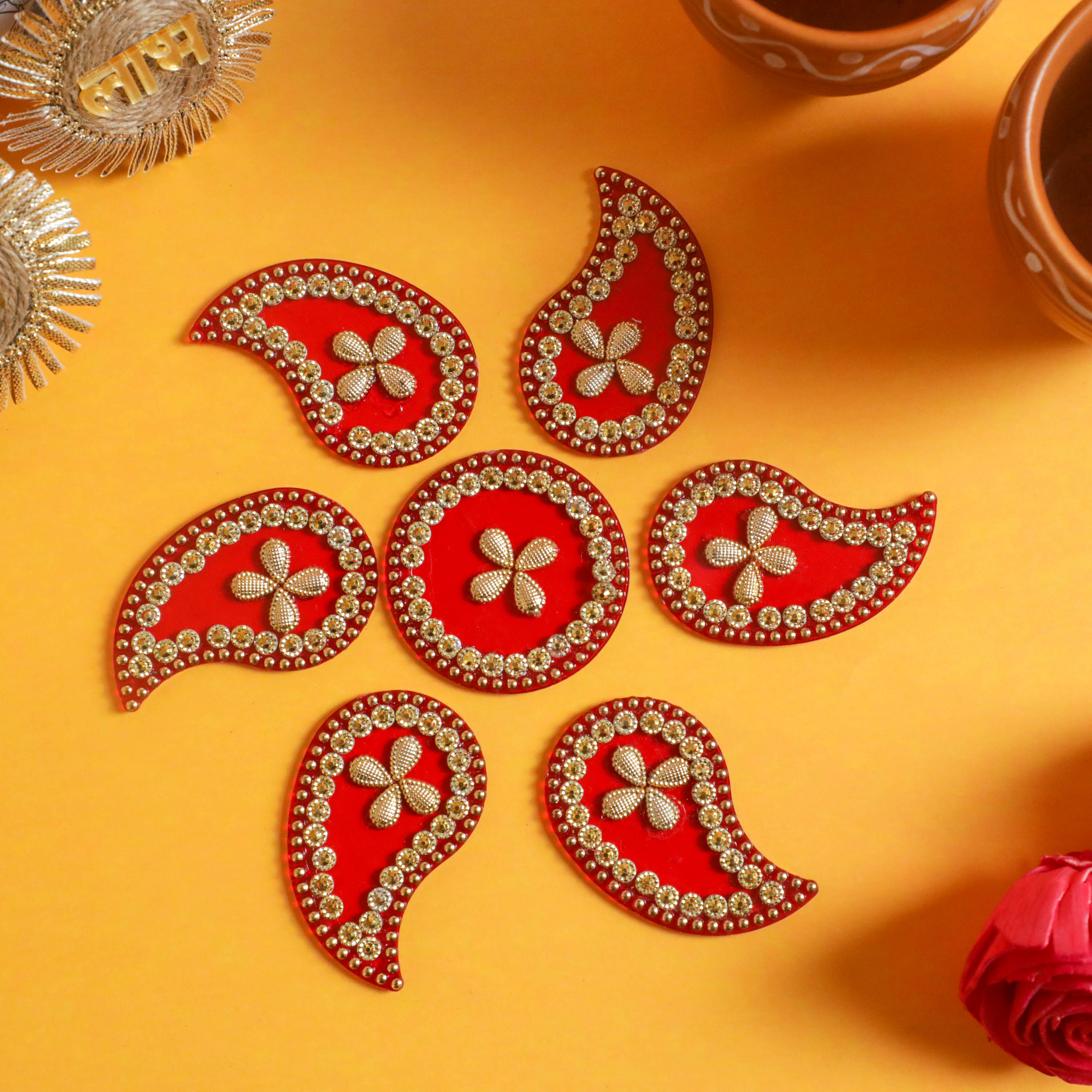 Red color rangoli with golden beads