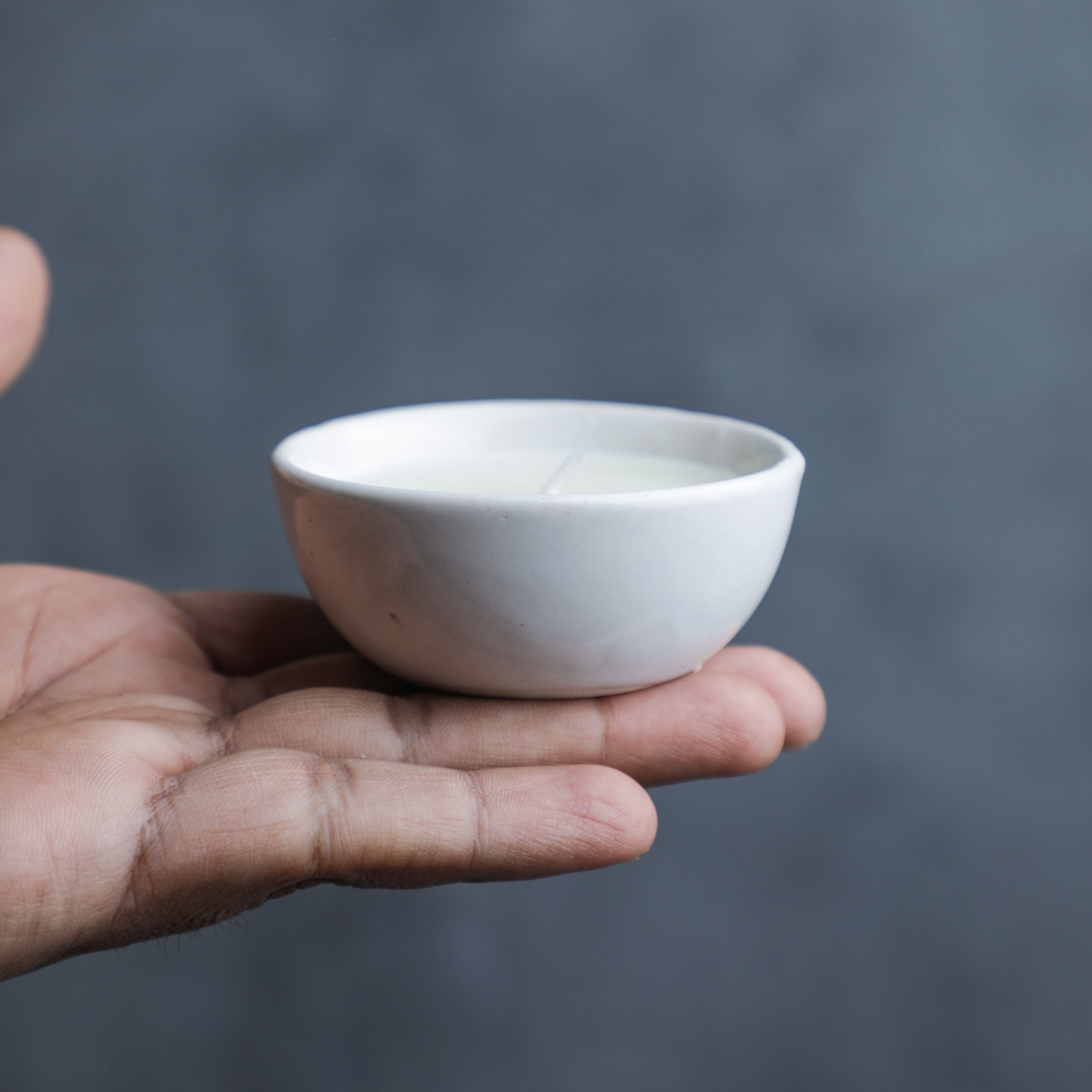 a person holding a jasmine scented candles